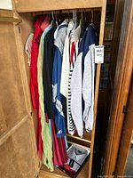 Clothing hanging in a closet including jackets, shirts, and dresses in multiple colors
