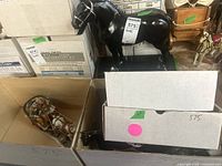 Overall view showing a large black ceramic horse statue and smaller horses in boxes around it.