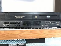 Front view showing complete combo unit with all buttons and ports visible, including VHS slot and DVD tray.