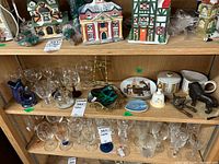 Shelf display with multiple animal figurines, blue Gluggle jug, glassware, plates, creamer and sugar bowl