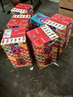 Multiple boxed mini gum ball machines and one Troll Doll gum bank arranged together.