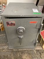 Front view of Gardall heavy duty safe showing combination dial and handle, with a Gardall logo sticker and some wear marks on the surface.