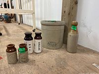 Shows the entire set including the Medalta crock, bottles, and salt and pepper shakers on a wooden surface.