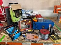 General view of lot contents including toolbox, staple gun, staples, spool of wire, cords, and assorted hand tools