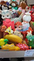 Assorted vintage rubber and plastic toys including a white cat, white duck, and various animal figurines in a box