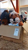 Box containing plush chipmunk and brown dog toys