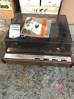 Front view of Vintage Columbia brand turntable with dust cover in place, wooden sides, and silver front panel with control buttons and speed selector visible.