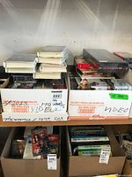 Two boxes of VHS tapes filled with mixed genre movies and shows, some with Disney titles visible.