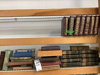 Shelf with large brown leather-bound Times Encyclopedia volumes with gold embossing numbering 10 volumes.