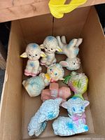Full box view of all vintage baby toys showing lambs, fish, and toy truck inside a cardboard box.