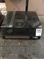 Full view of the vintage BSR McDonald 5500 turntable with closed transparent dust cover on a concrete floor.