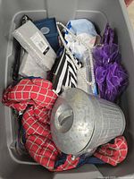 Top view of grey bin filled with various decorative items and fabrics