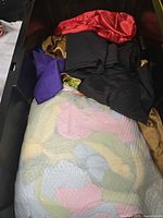 Container with assorted sashes and tablecloth fabrics in various colors