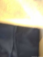 Close-up photo showing a single blue polyester table napkin under warm lighting.