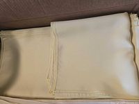 Folded yellow cloth napkins stacked neatly in a box.