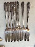 Eight forks arranged side by side showing handles and tines