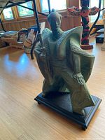 Front and side views of the Asian-inspired male figurine statue in traditional attire, standing on a wooden display base.