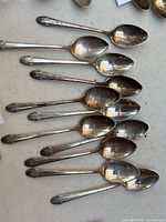 Overhead view of 12 spoons arranged on surface showing bowls and handles