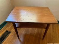 Top view showing rectangular wooden surface with visible wood grain and wear marks in natural light.