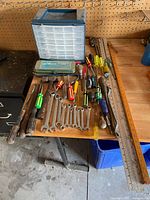 Photo of entire lot on wooden table showing hand tools, storage drawers, and measuring rulers