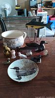 Front view of 11 wildlife collectible decor items including ceramic bowl, plates, bird and fish figurines arranged on a table.
