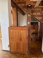 Full side view of the solid wood home bar showing vertical grooved paneling and live edge natural cracks on corners.