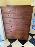 Front view of medium brown stained wooden chest showing 8 drawers