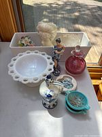 Full lot on white table by window, showing all porcelain, ceramic, glass and milk glass items as described.