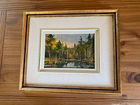 Front view of the oil painting in its white and gold double mat and gold wooden frame