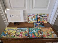 Seven Berenstain Bears books displayed on a wooden surface against a white door background.