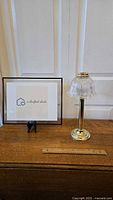 Full view of the candle lamp beside a frame and ruler showing size and condition