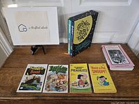 Photo showing assortment of young reader's books on a table with a framed label included, featuring four paperback books and a boxed set