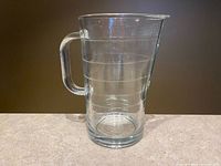 Front view of the clear ribbed IKEA SVEPA glass pitcher on countertop showing handle and ribbed horizontal rings.