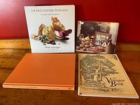 Four vintage culinary and lifestyle books shown: La Mia Cucina Toscana with dust jacket, A Taste of Ireland softcover, The Vinegar Book with illustrated cover, and The Country Store with orange cover.