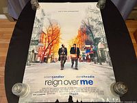 Front side of the movie poster with actors Adam Sandler and Don Cheadle walking on a New York street with tagline and film details visible.