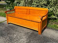 Solid pine daybed bench in warm honey finish with curved arms and panel back, shown closed.