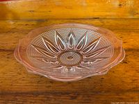 Top view showing scalloped edge and sunflower petal pattern with textured background on clear glass bowl.