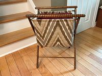 Front view showing zigzag patterned fabric bag with turned wood frame and handles, standing open.