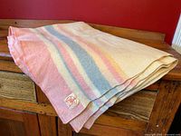 Folded wool blanket showing pastel stripes and H.B. Horn Bros label corner.