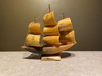 Photo of the handcrafted sailing ship figurine made of genuine horn on a flat surface showing the full figure and base