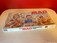 Top view of the MAD Magazine board game box showing colorful caricature artwork and title.