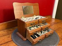 Jewelry box with drawers open displaying assorted jewelry inside