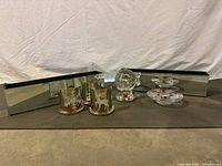 Overview of mirrored long centerpiece trays, three glass tea light holders, reindeer musical snow globe