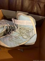 Left side view of Bauer React women's ice skate showing detailed side graphics and lacing system.