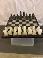 Chess set with black and white onyx pieces arranged on the onyx chessboard showing full set and board.