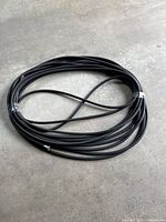 Full coiled black rubber hose on concrete floor