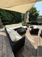 Overhead view of L-shaped sectional, single chair and coffee table on deck under shade sail.