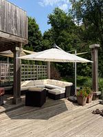 Full view of deployed off-white 11-foot cantilever umbrella shading patio seating