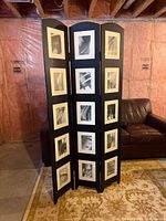 Front view of the triple panel photo screen room divider showing black wood construction with 4x6 photo openings filled with monochrome photos.