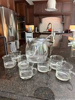 Full set of punch bowl, ladle and 7 cups on a dark kitchen counter showing complete lot contents